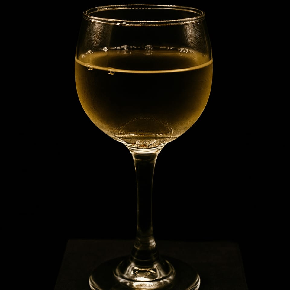 A glass of golden beer with condensation, set against a dark background at Kelly Brothers Irish Pub.